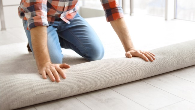 Man rolling carpet for installation | Gainesville CarpetsPlus COLORTILE